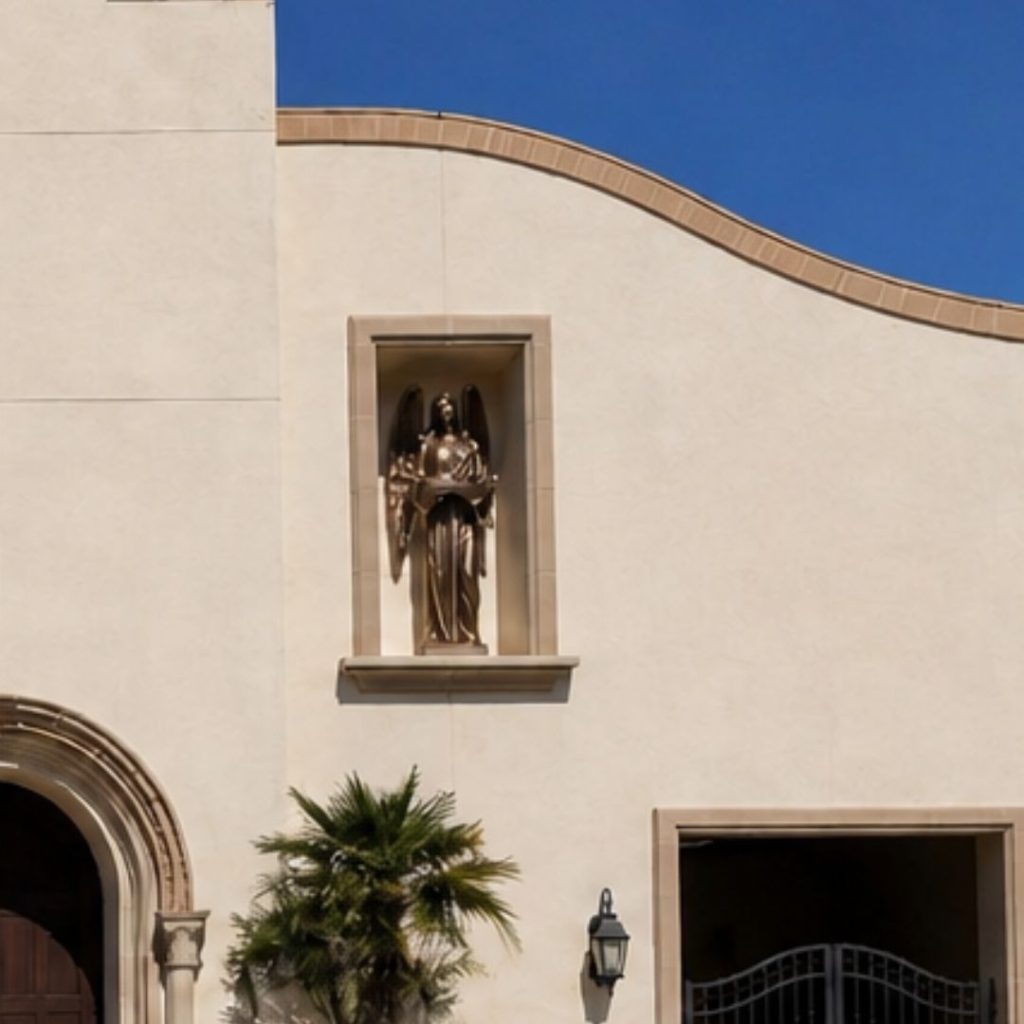 Close-up of bronze-finish fiberglass entrance angel installed high on the facade of Good Shepherd Catholic Parish in Visalia, California